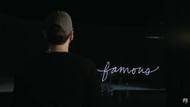 A still from Stans (2025) showing Eminem facing the word "famous" onscreen (Image via EminemMusic)